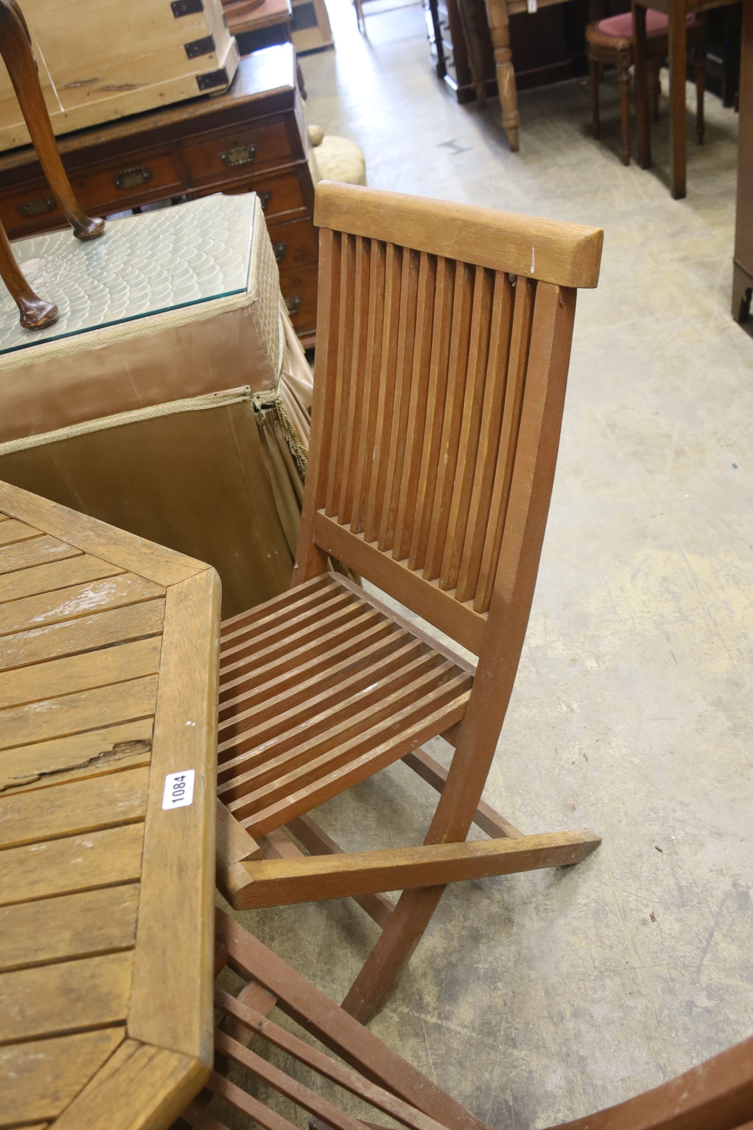 An octagonal teak garden table, width 111cm, height 69cm and four chairs